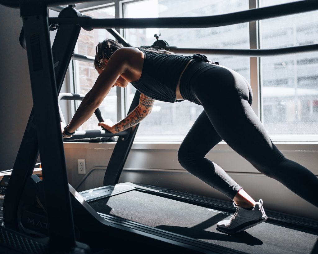 woman in gray tank top and black leggings doing exercise